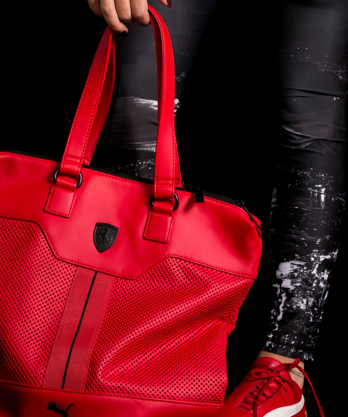 person holding red Puma leather tote bag