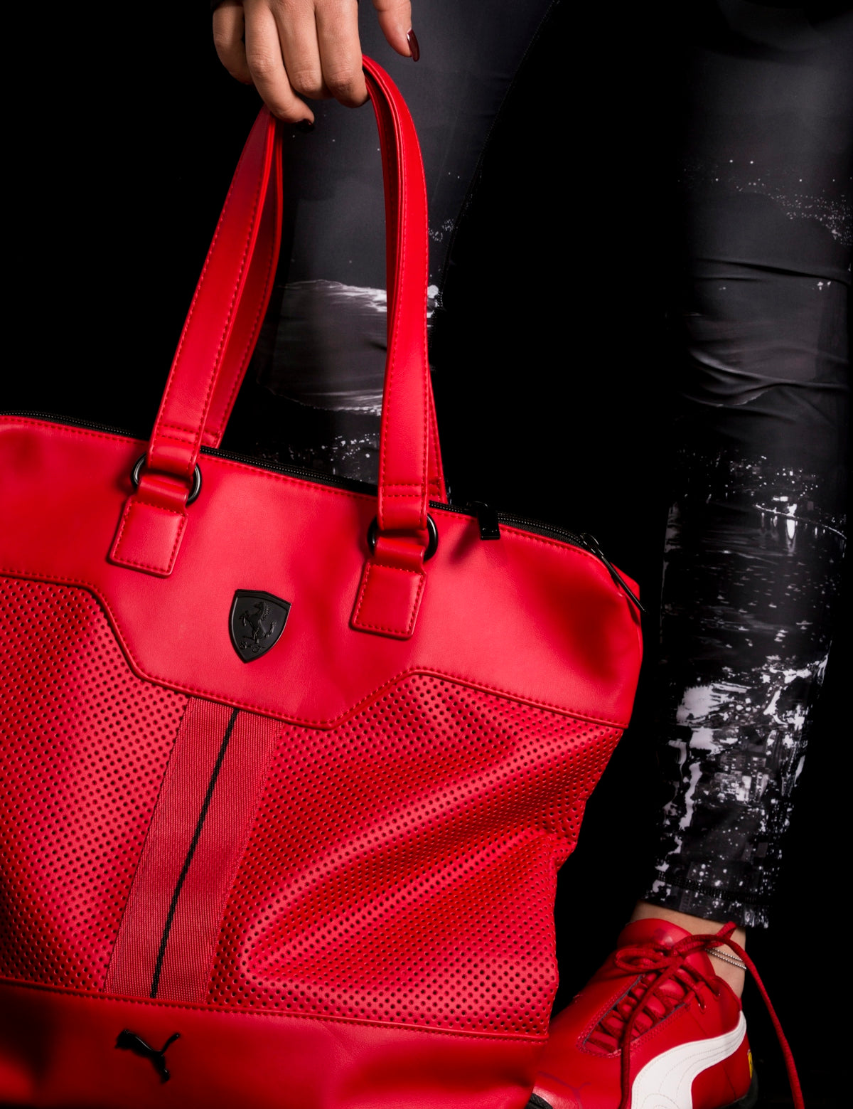 person holding red Puma leather tote bag