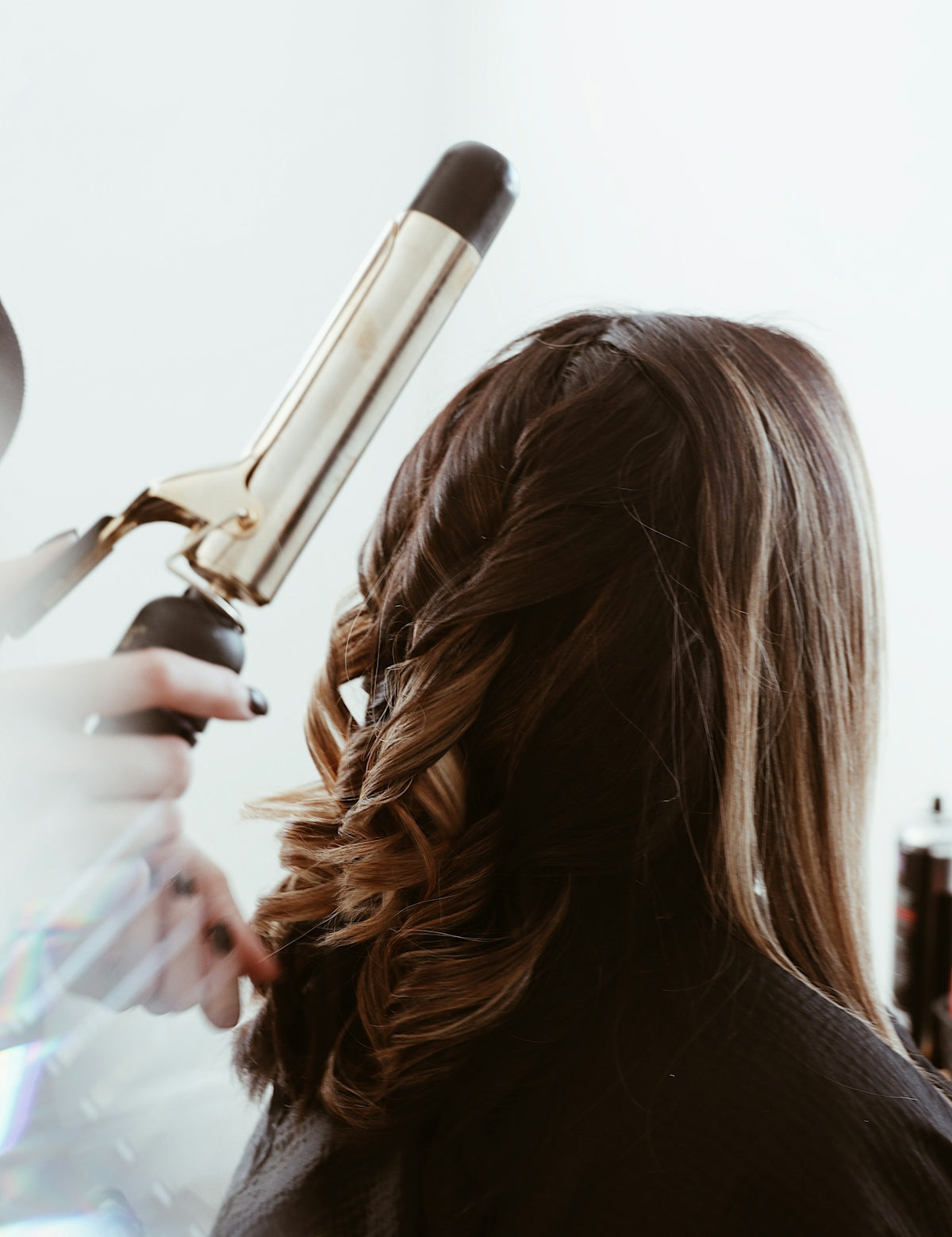 person holding gray hair curler