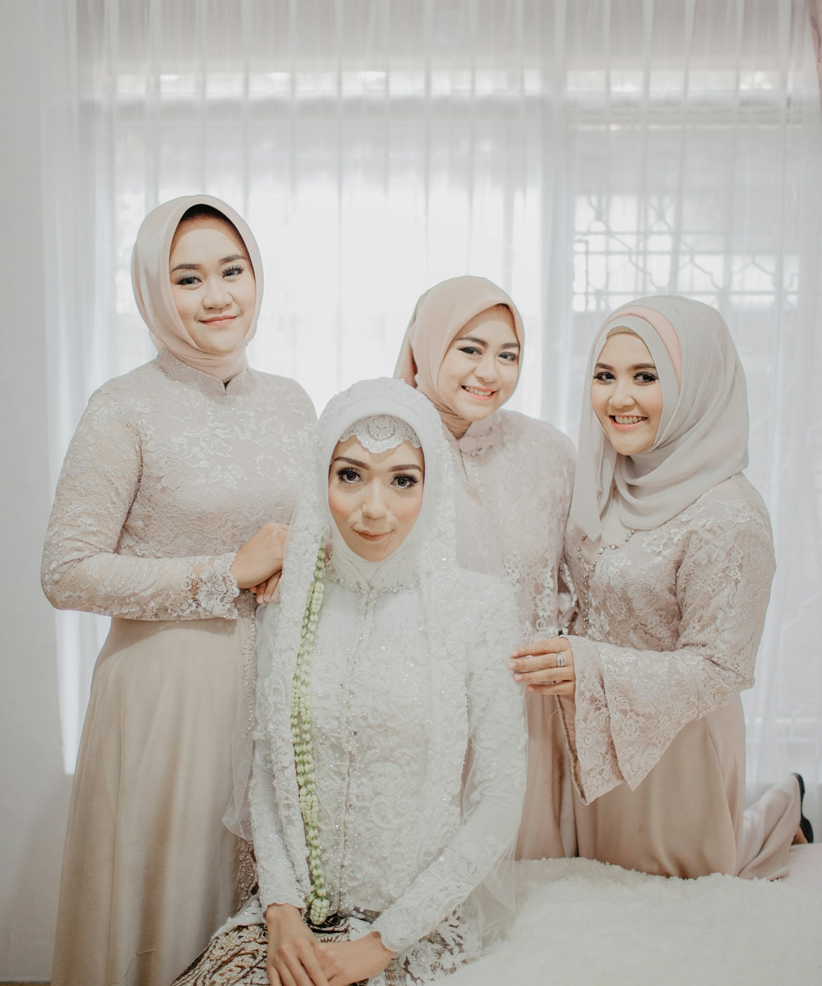 2 women in white hijab standing near white curtain