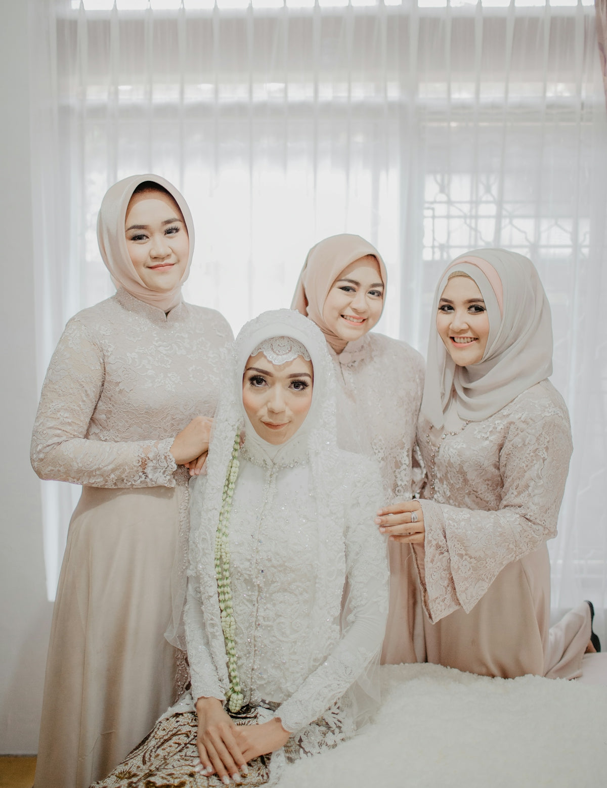 2 women in white hijab standing near white curtain