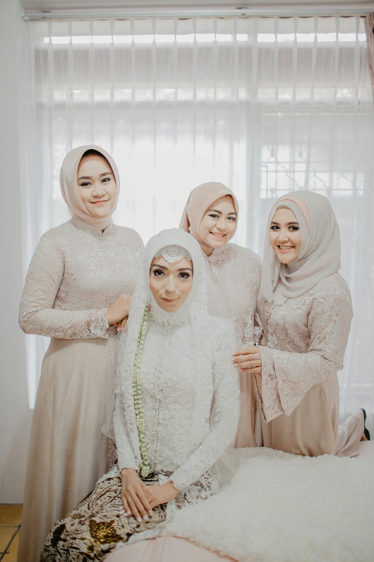 2 women in white hijab standing near white curtain