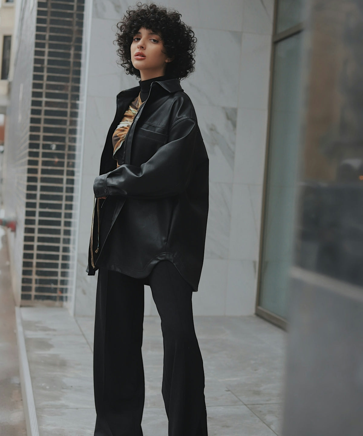 woman in black coat standing on white floor