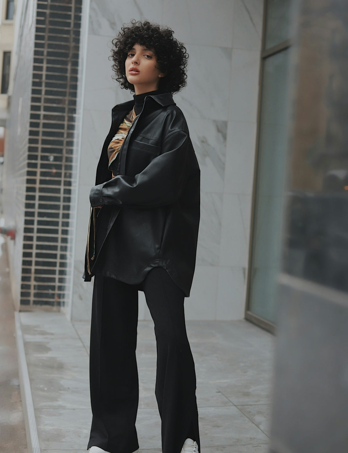 woman in black coat standing on white floor
