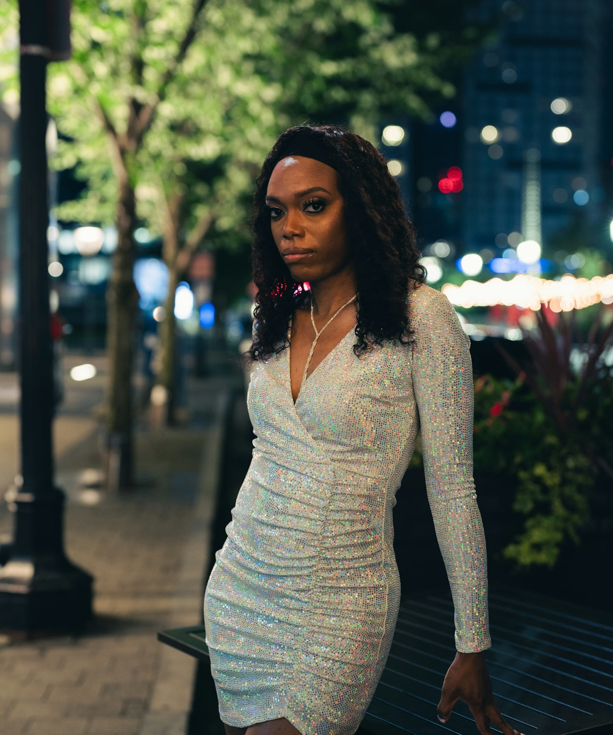 woman in white long sleeve shirt and gray skirt sitting on bench during night time