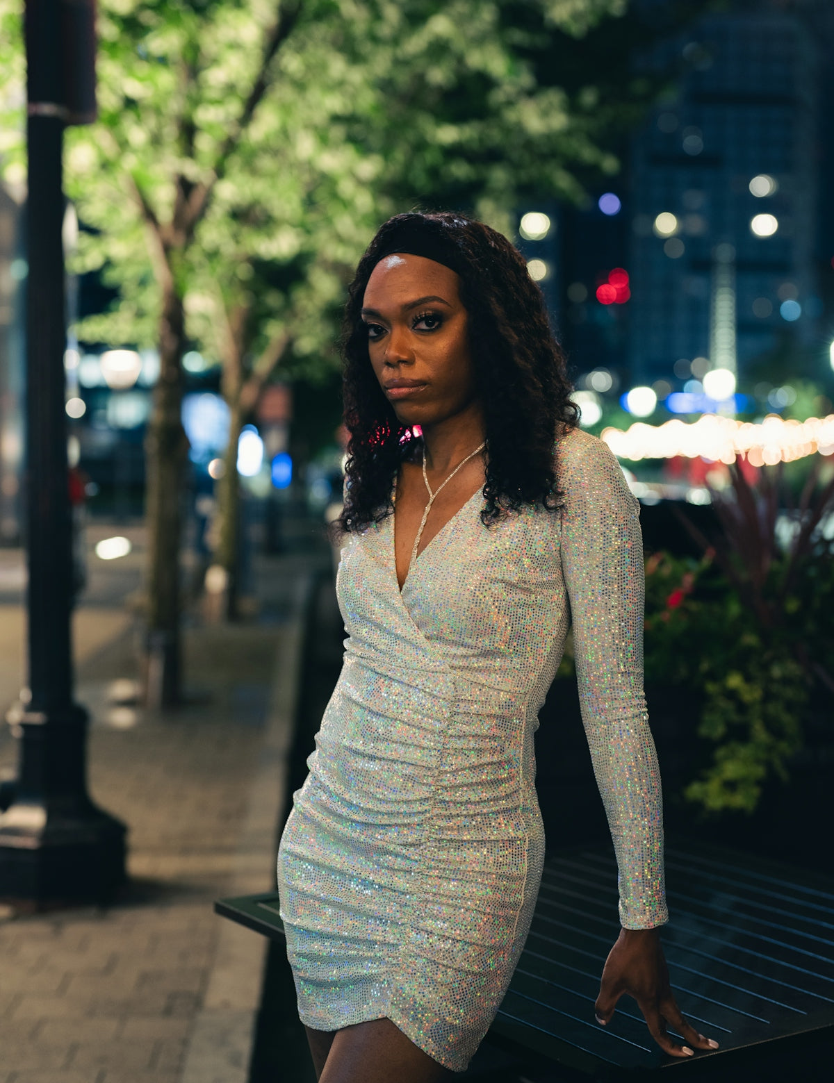 woman in white long sleeve shirt and gray skirt sitting on bench during night time