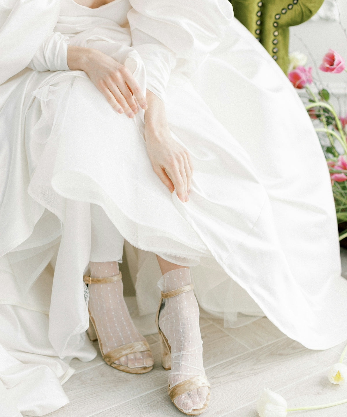 a woman in a white dress sitting on a green chair