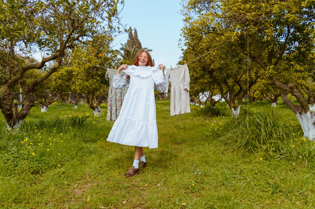 a woman in a white dress standing in a field