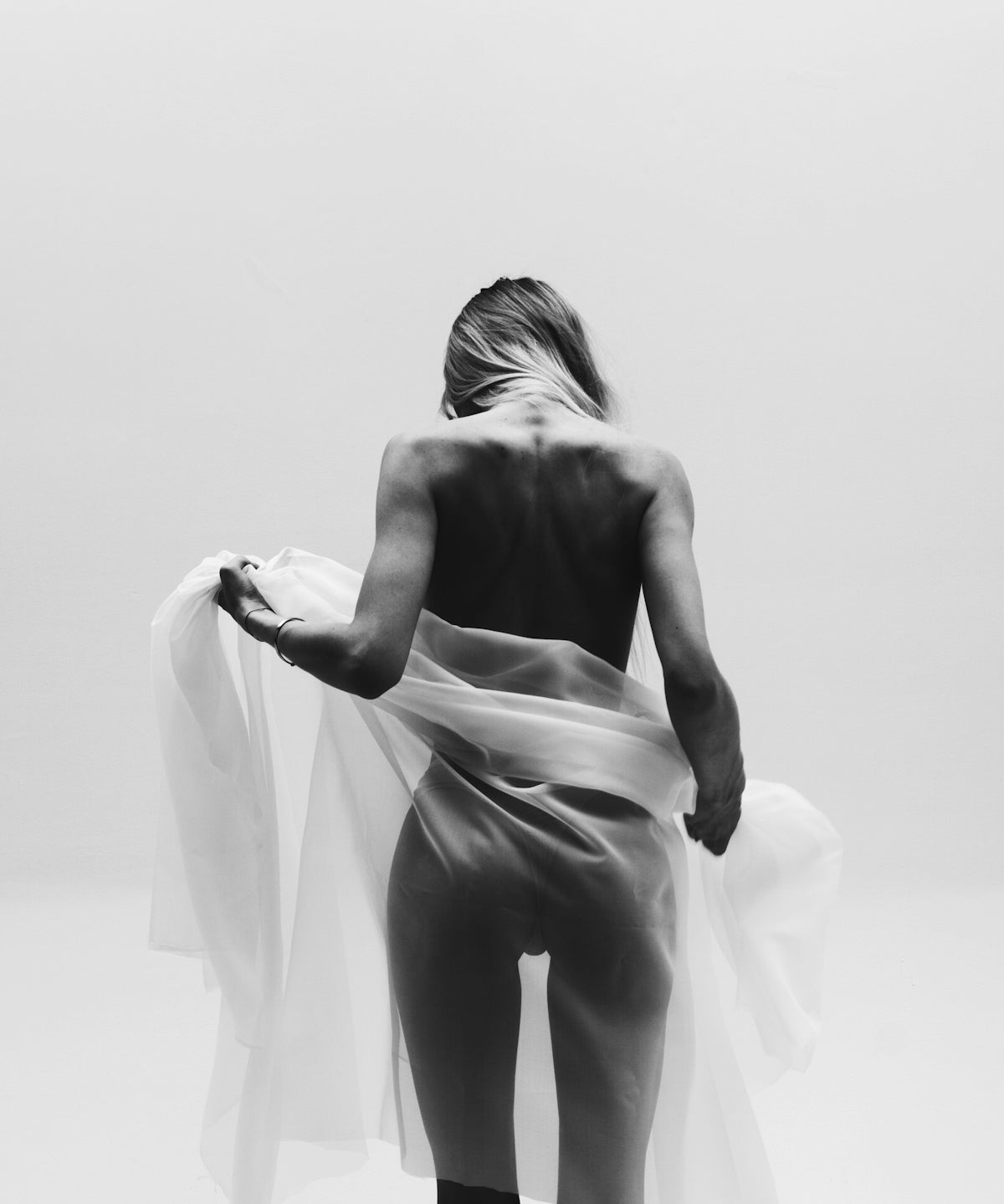 A woman is standing in a white room