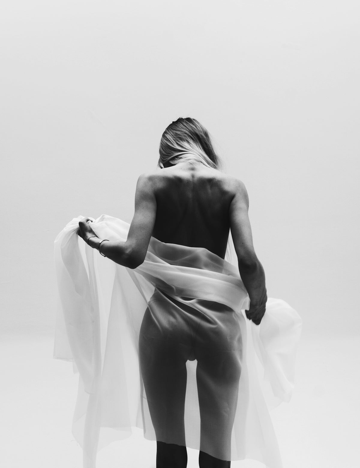A woman is standing in a white room