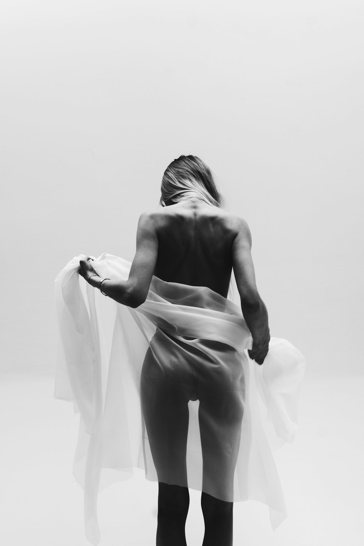 A woman is standing in a white room