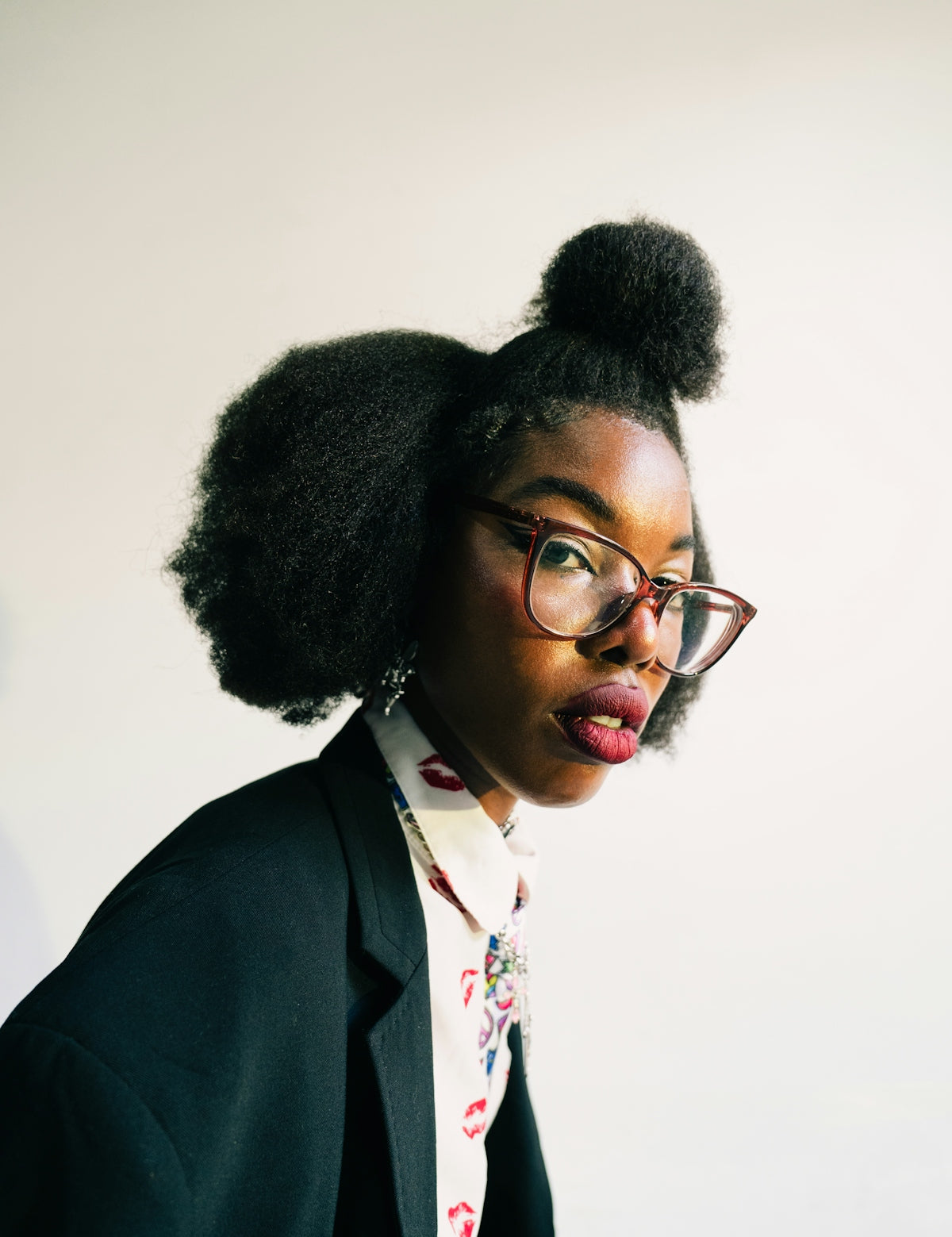 Woman with glasses and styled hair wearing a blazer