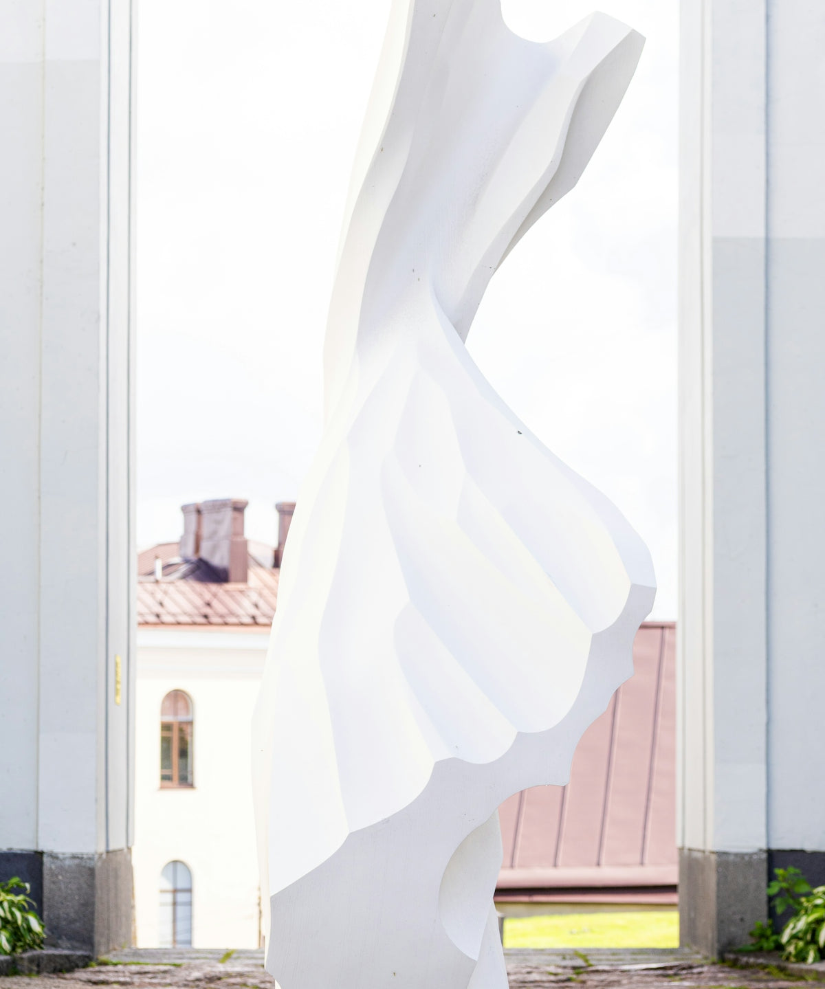 Modern white sculpture against a bright sky.