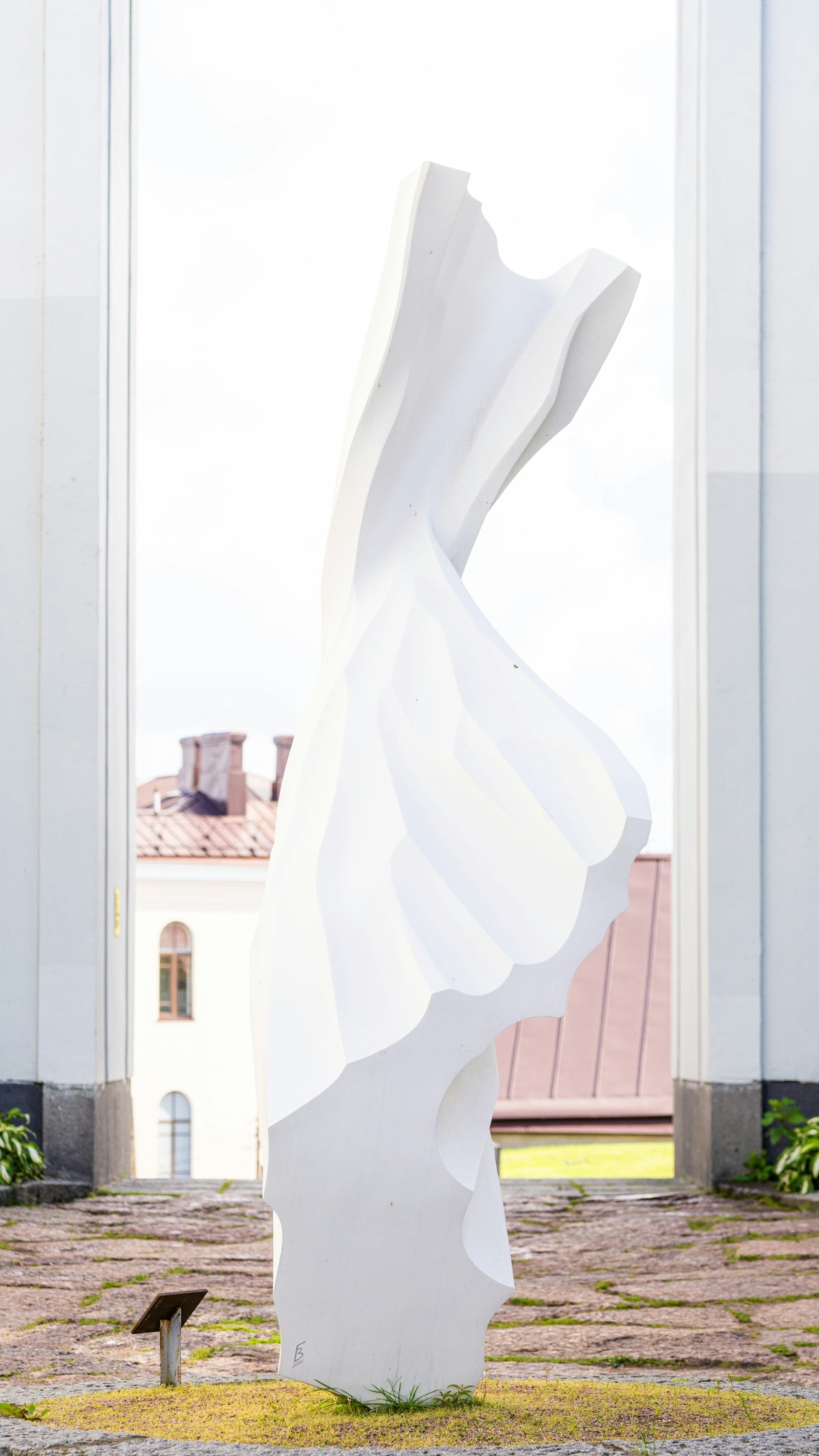Modern white sculpture against a bright sky.