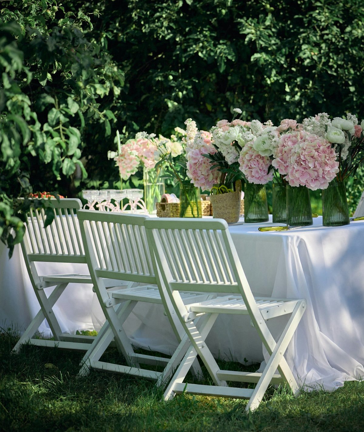 White table and chairs with pink flowers in a garden
